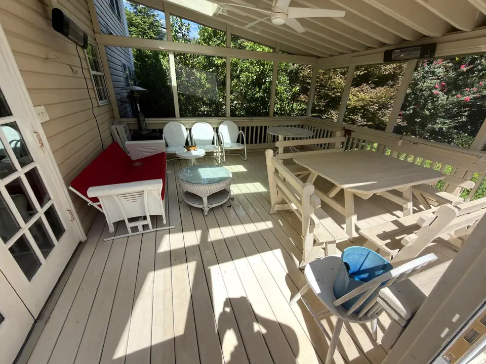 Screened porch with wood flooring and outdoor furniture