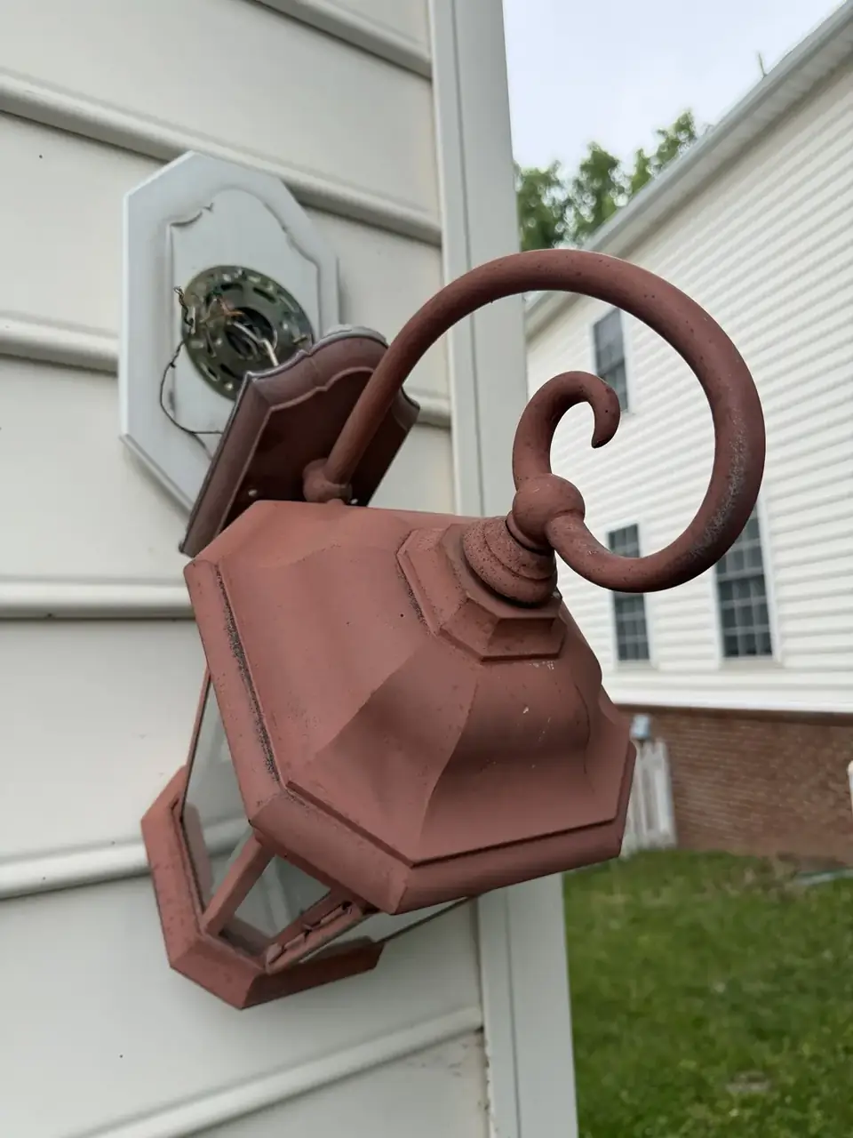 Original exterior wall lantern hanging away from its mounting point