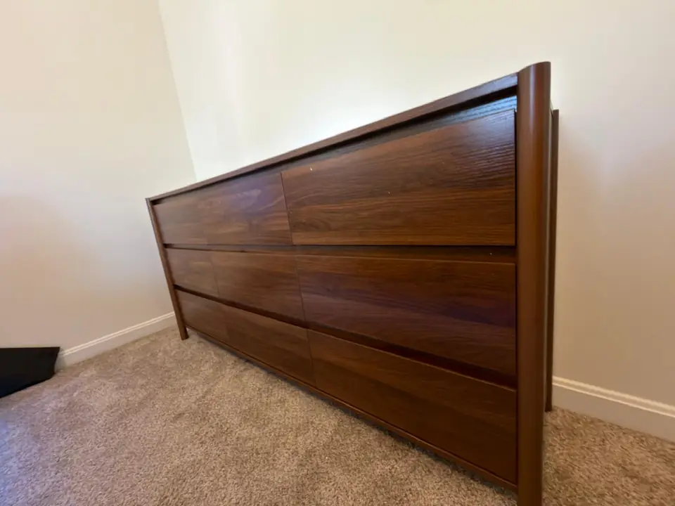 Assembled brown dresser against a bedroom wall