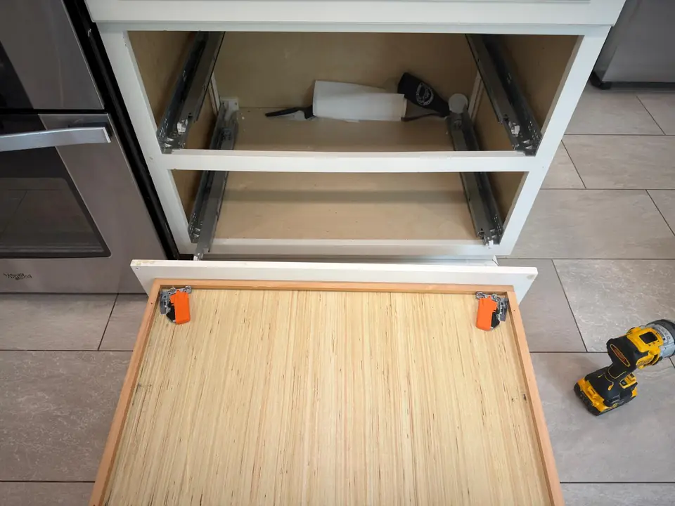 Kitchen drawer removed with cabinet slides exposed during repair