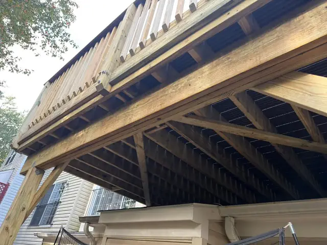 Underside of a raised deck showing beams and joists