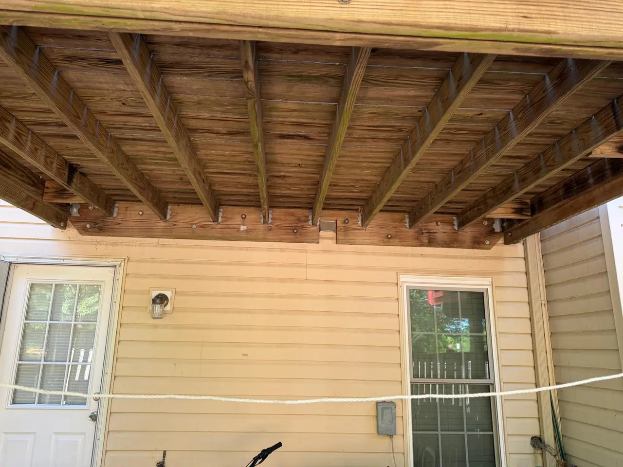 Original deck joists and ledger connection before the rebuild