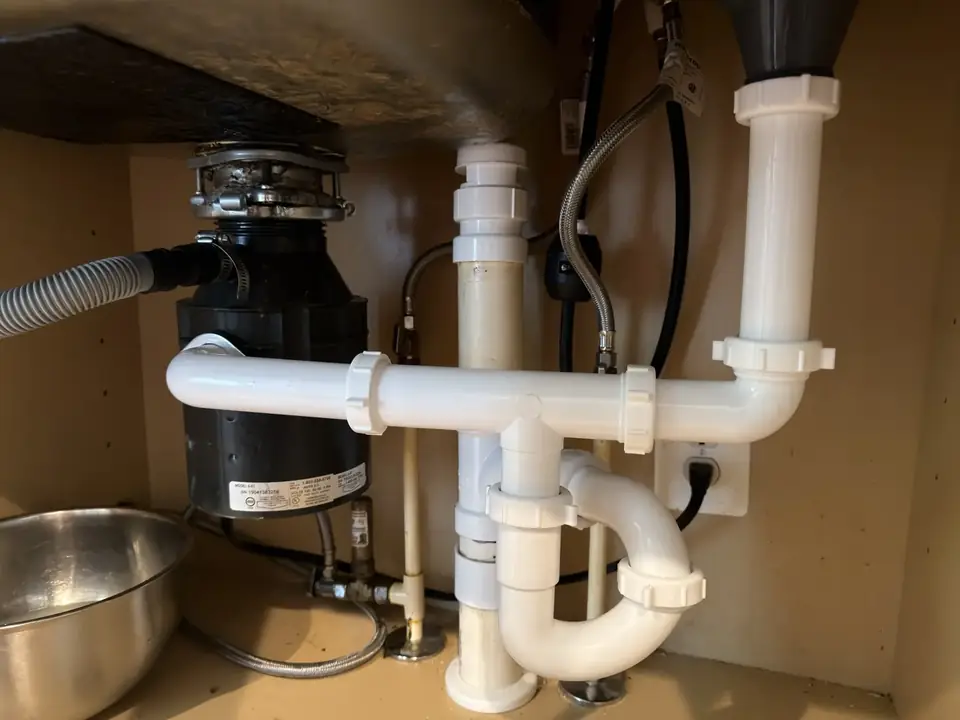 Completed rigid drain connections beneath a double kitchen sink