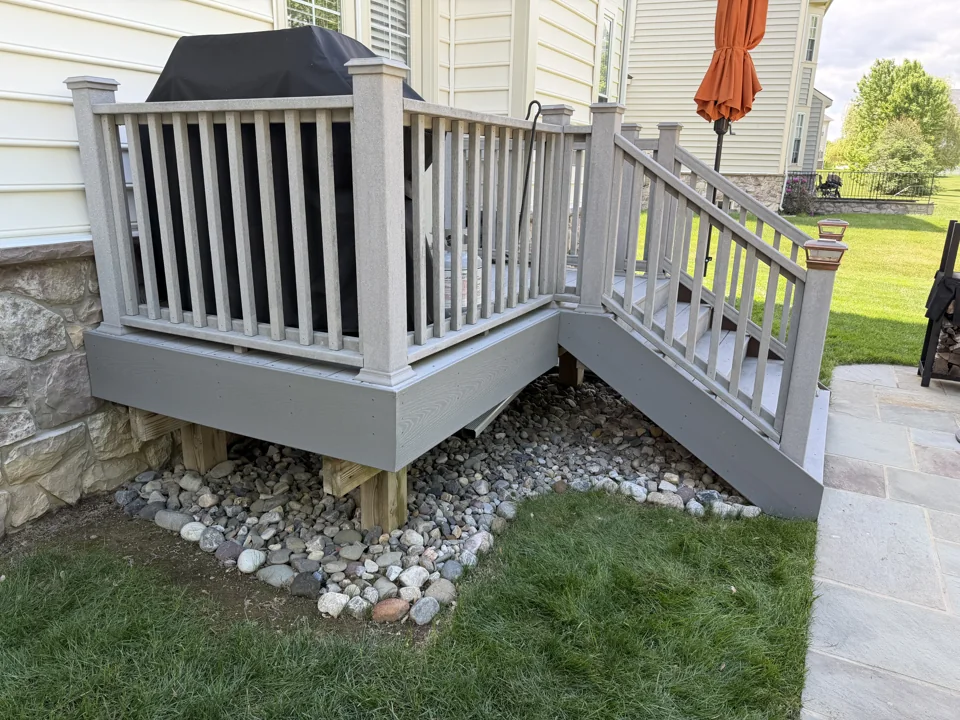 Gray deck railing and stairs with a decorative stone border